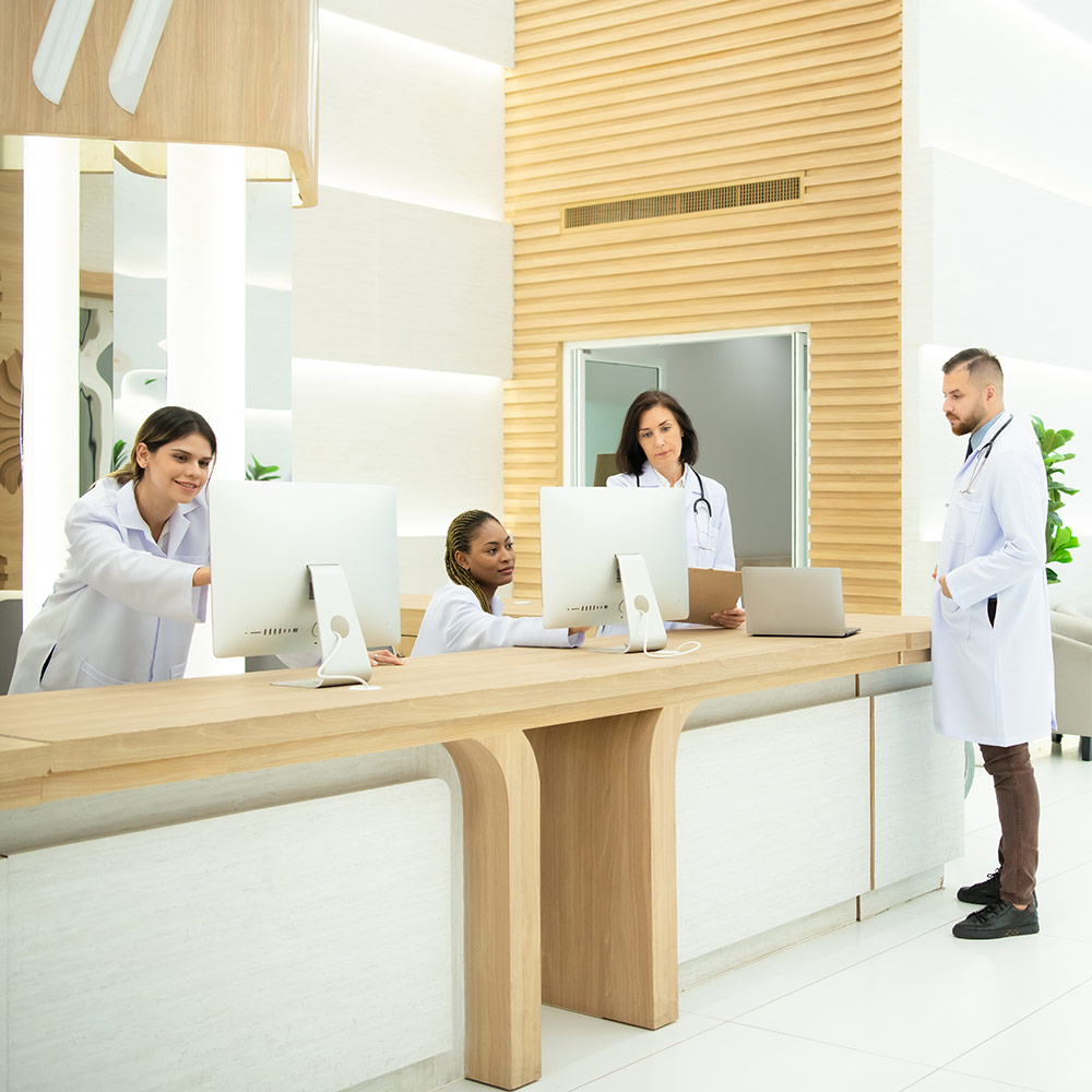Healthcare facility front desk with receptionists and doctors